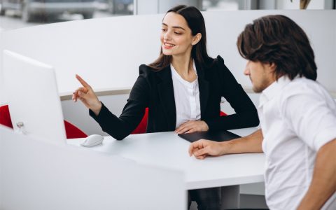 man-talking-with-female-sales-person-in-car-show-room